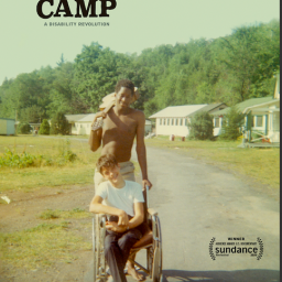 Image Description: The poster for Crip Camp, which features a vintage image of two Jened campers, one standing behind the other's wheelchair with a summer camp scene in the background. At the top left corner of the image, black text reads: "Crip Camp, a Disability Revolution."